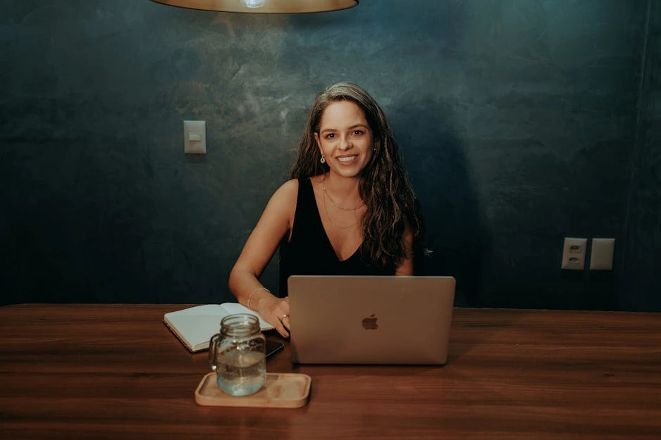 Uśmiechnięty analityk danych pracujący przy laptopie w nowoczesnym biurze